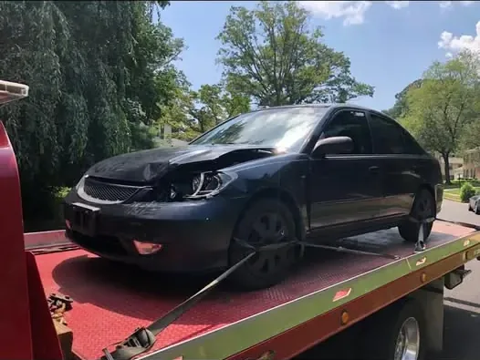 Damaged Honda Civic strapped down on the flatbed